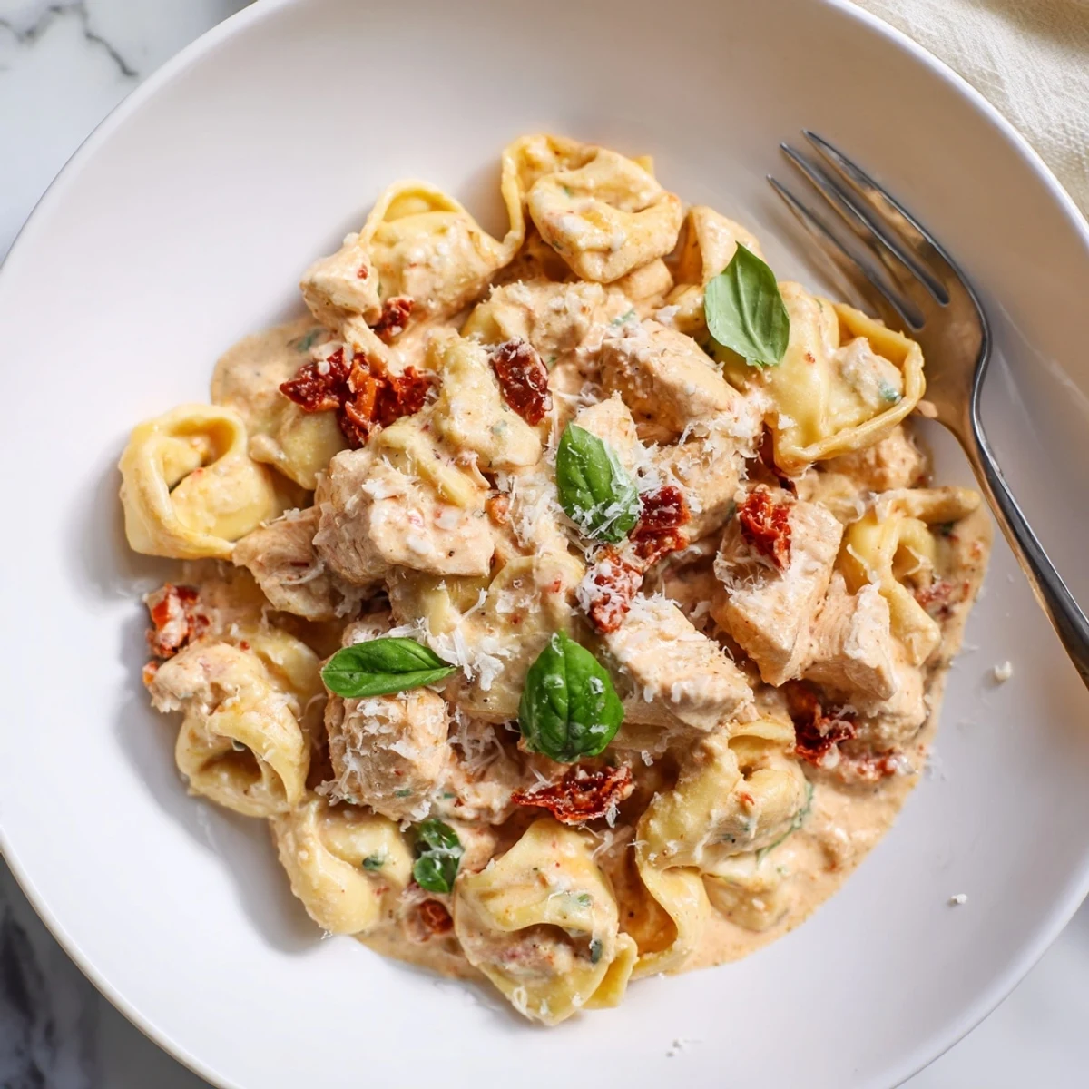 Golden chicken and cheese tortellini swimming in rich parmesan cream sauce