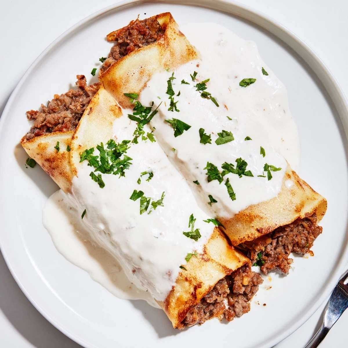 Golden Hortobágyi palacsinta filled with savory paprika meat ragout and creamy sour cream sauce