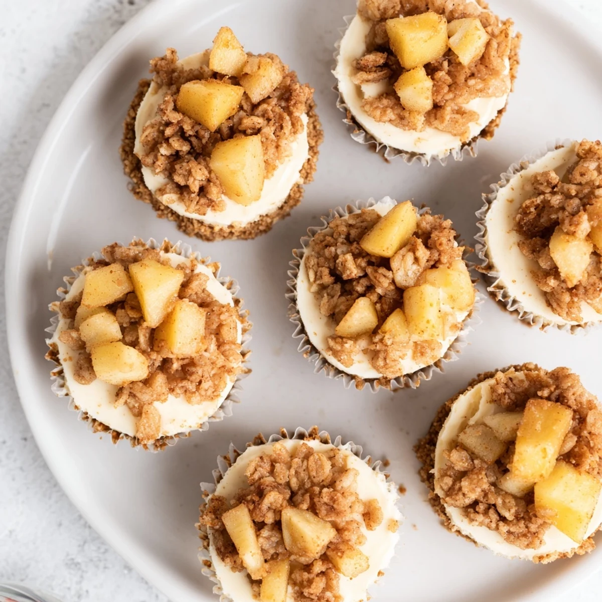 Mini cheesecakes topped with warm spiced apples and crispy cinnamon oat mixture for dessert