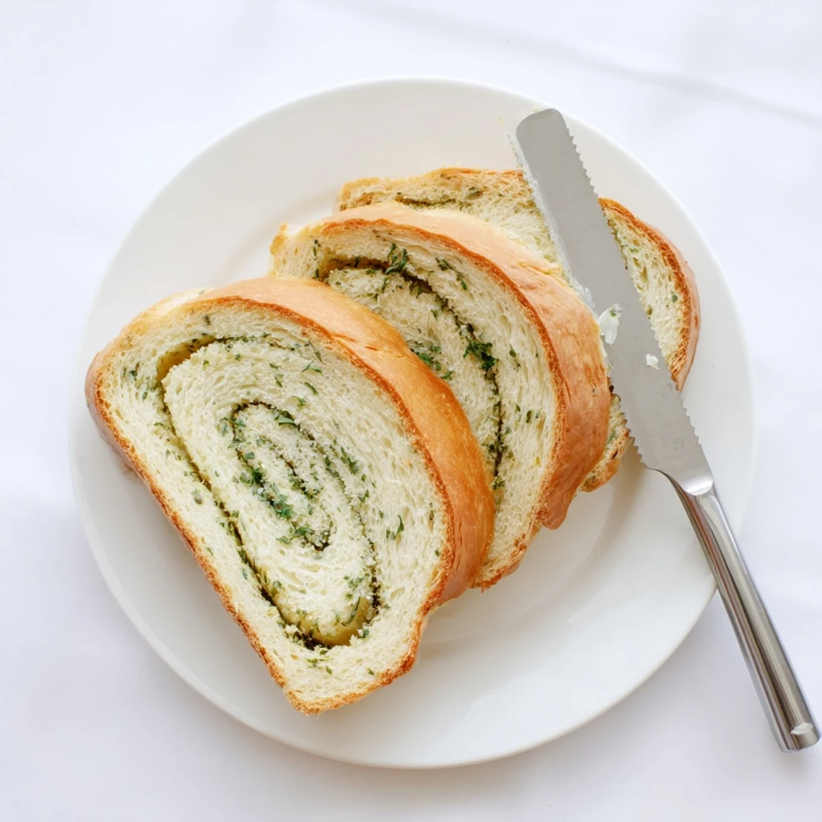 Soft garlic and herb bread pieces showing flecks of fresh parsley and rosemary inside