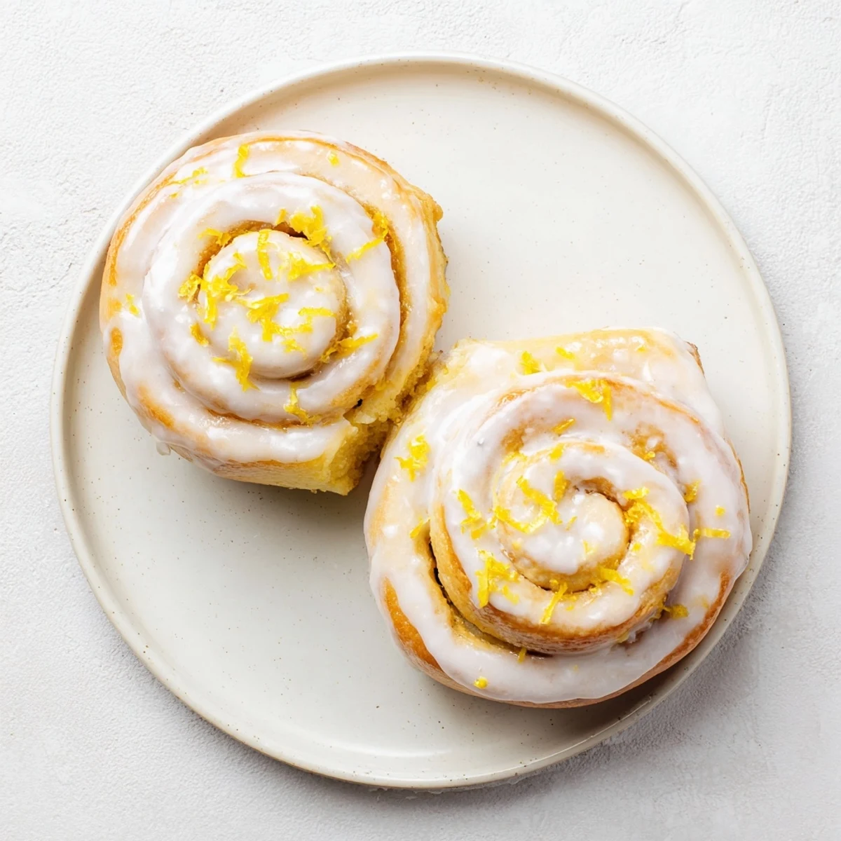 Golden lemon rolls with sweet lemon filling and glossy white glaze topping
