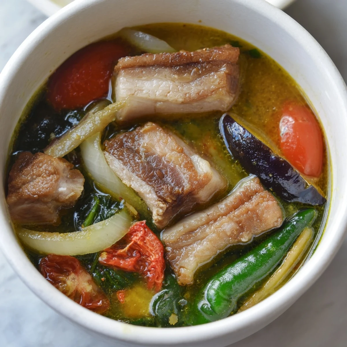 Vibrant Filipino Sinigang sour soup brimming with colorful veggies in tangy tamarind broth