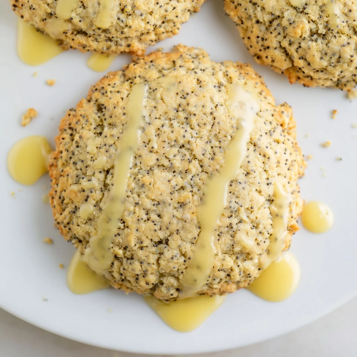 Chewy lemon poppy seed cookies speckled with tiny black seeds arranged on a white ceramic serving plate