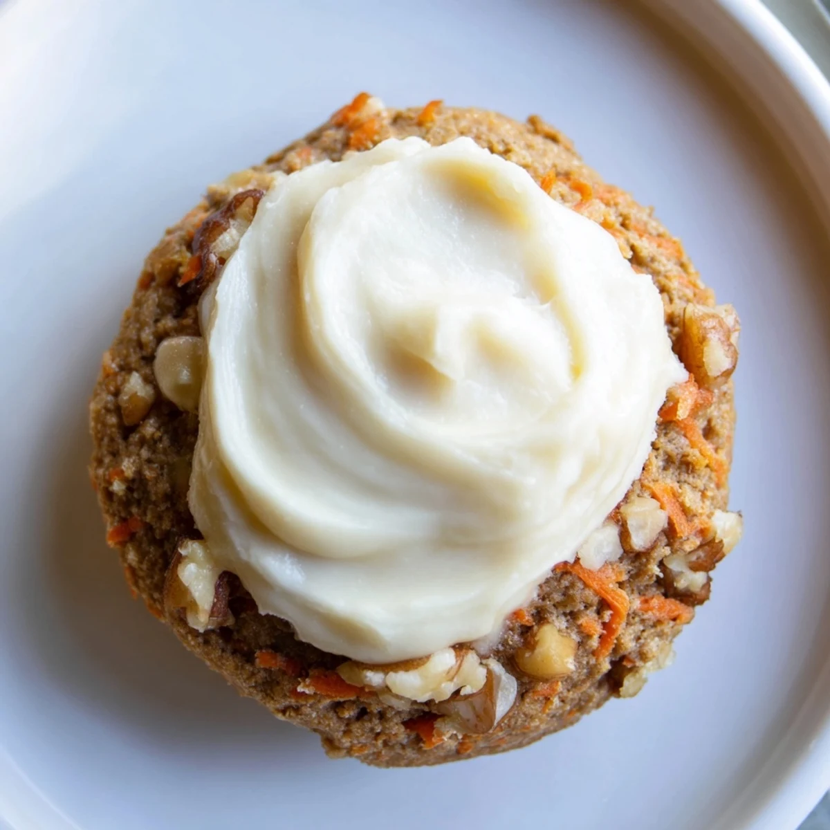 Soft, spiced Crumbl carrot cake cookies topped with thick, creamy swirls of tangy cream cheese frosting.