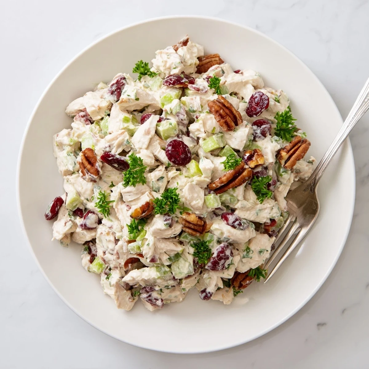 Creamy cranberry pecan chicken salad served in a white bowl with dried cranberries and toasted pecans visible