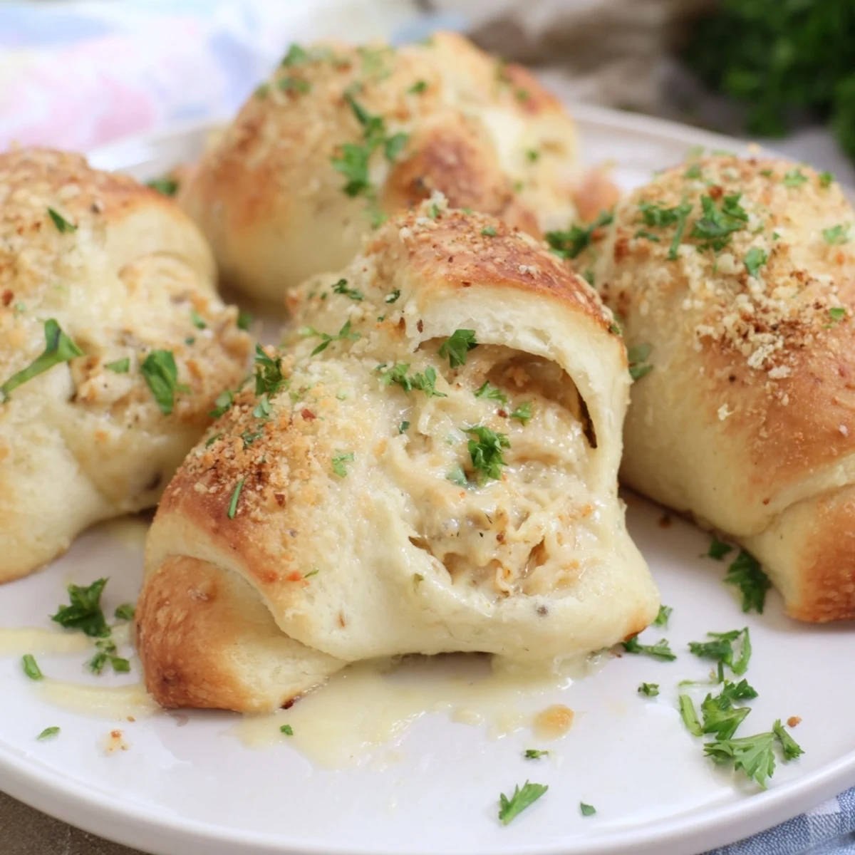 Tender shredded chicken stuffed in golden pastry pillows topped with velvety parmesan cream sauce