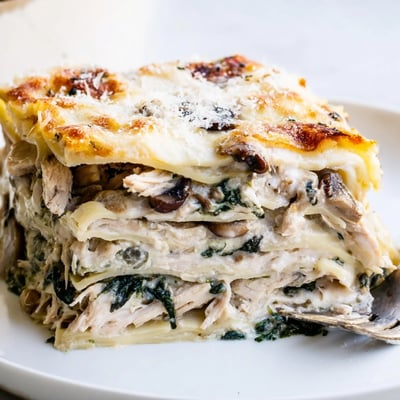 White chicken lasagna sliced into thick layers of tender chicken and spinach